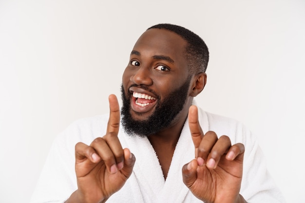 Black guy wearing a bathrobe pointing finger with surprise and happy emotion. 