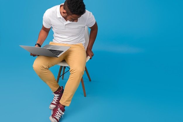 Black guy with laptop sitting on chair