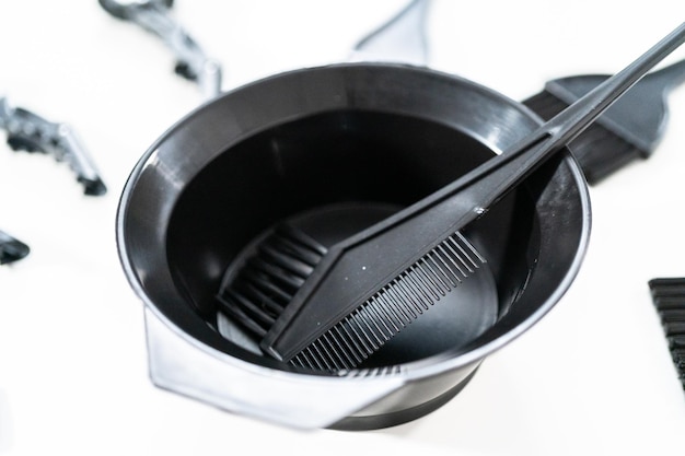 Black hair color dye kit with mixing bowl on a white background.