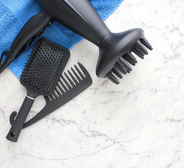 Photo a black hairbrush with a blue towel on it that says  the word