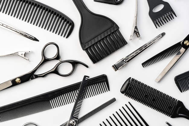 白い背景の黒いヘアドレッシングツールと様々なヘアブラシ