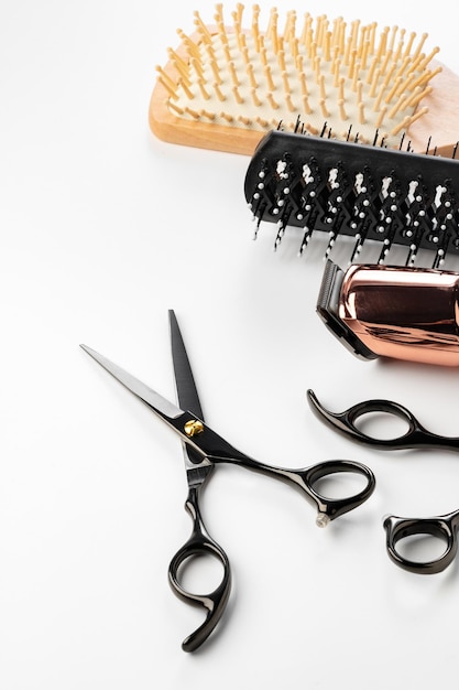 Black hairdressing tools and various hairbrushes on white background