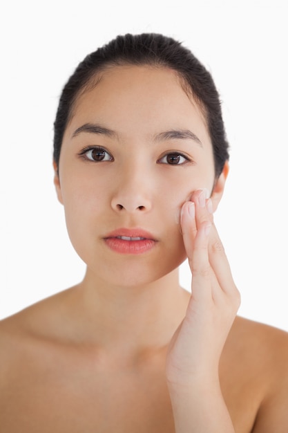 Black haired woman touching her face