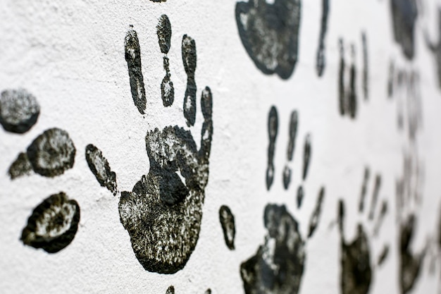 Photo black hand-prints on a wall