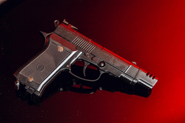 Pistola nera sul nero con la riflessione si chiuda