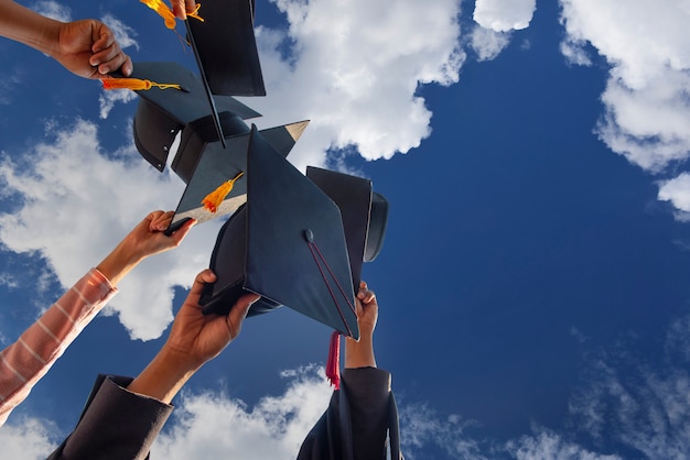 Cappello nero dei laureati che galleggiano nel cielo.