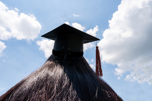 Black hat of the graduates floating in the sky.