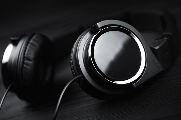 Photo black headphones on black wooden dark background