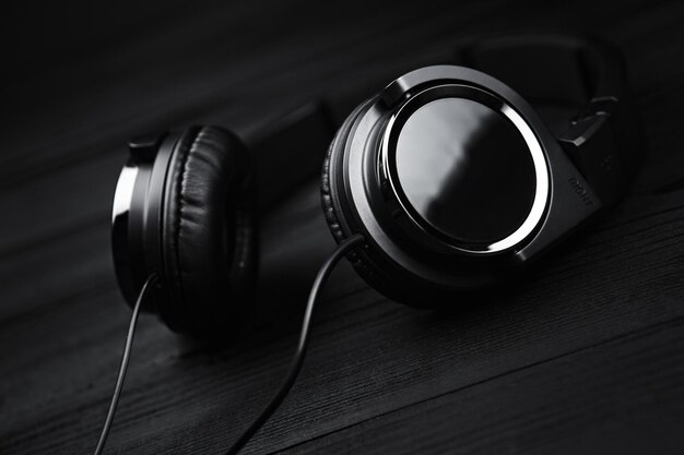 Photo black headphones on black wooden dark background