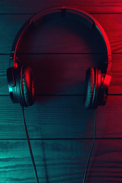 Photo black headphones on dark wooden background vintage style