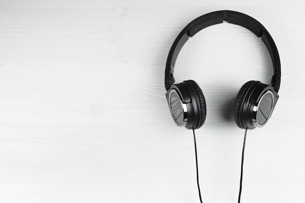 Photo black headphones on white wooden background music concept