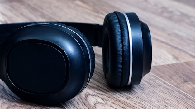 Black headphones on a wooden background closeup