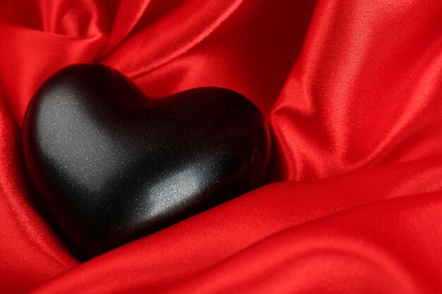 Black heart on fabric background