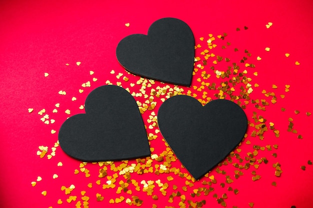 Черное сердце на красном фоне на день святого Валентина.