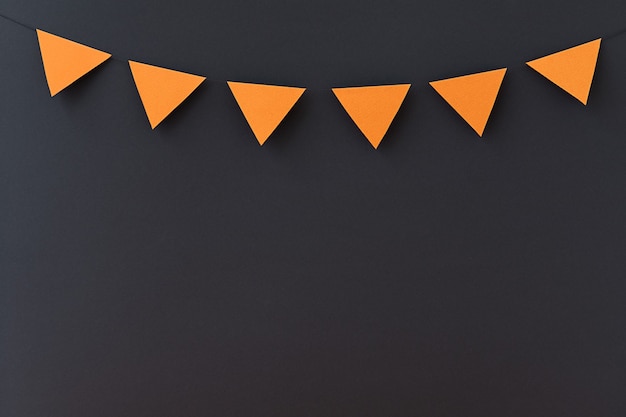 Photo black holiday background with orange small flags and place for text