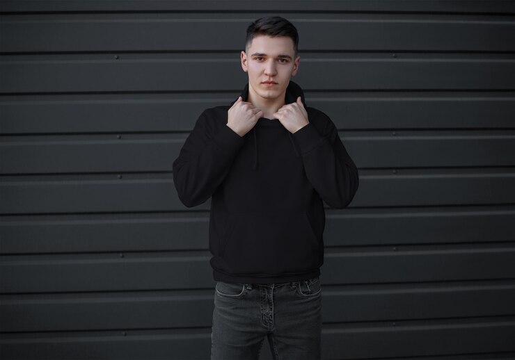 black hoodie with a pocket on a young guy in jeans front view long sleeve sweatshirt