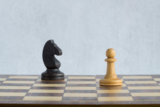 A black horse chasing a white pawn on the chessboard