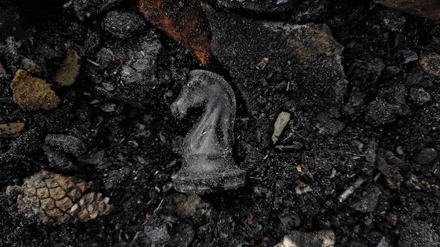 A black horse chess piece is among the rubble