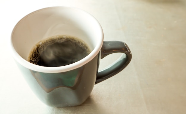 Caffè caldo nero in tazza di caffè grigio e bianco al mattino. caldo caffè caldo