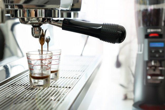 カフェでコーヒーメーカーとブラックホットコーヒー