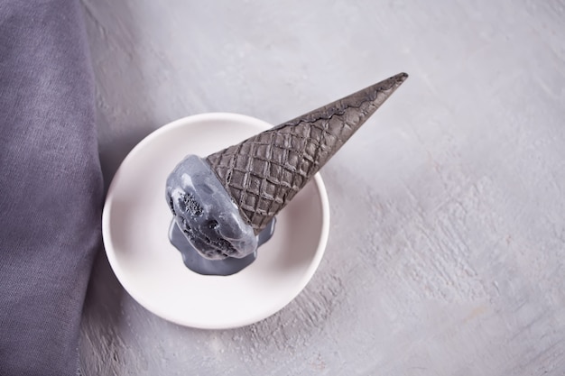 Black ice cream in traditional portioned ice cream cones. 