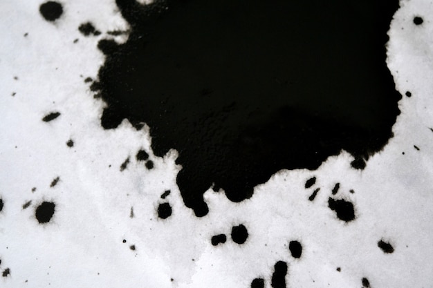 Black Ink Conveyed Over White Close-up Paper. Abstract Background isolated on white background. Ink Stains Spread Out and Absorbed Into the Paper Macro.