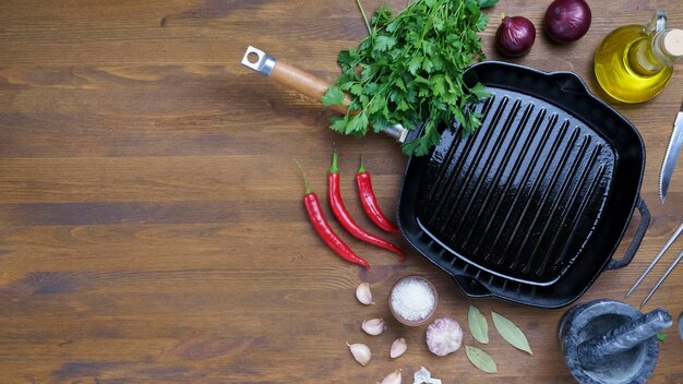 Black iron empty grill pan on wooden texture