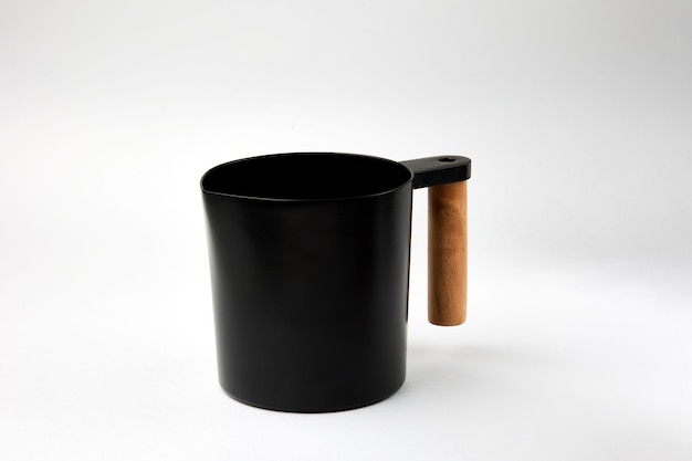 Photo black jar with wooden handle stands on white background