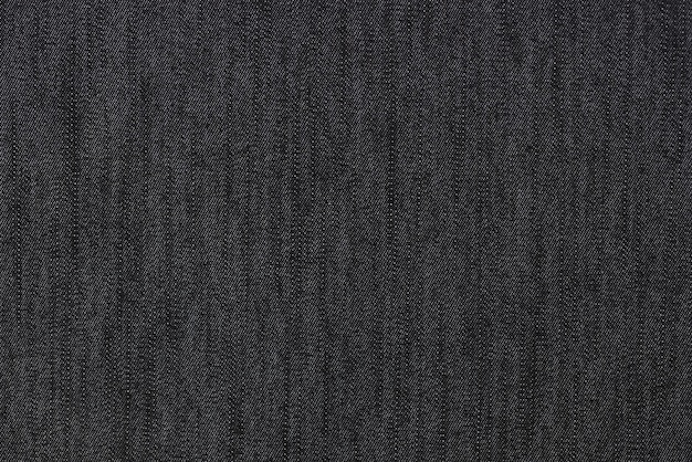 ブラック ジーンズのテクスチャまたは背景のデニム繊維は、ブラック デニム生地のクローズ アップ