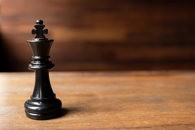 Black king chess on wooden background Leader challenge planning business strategy to success concept