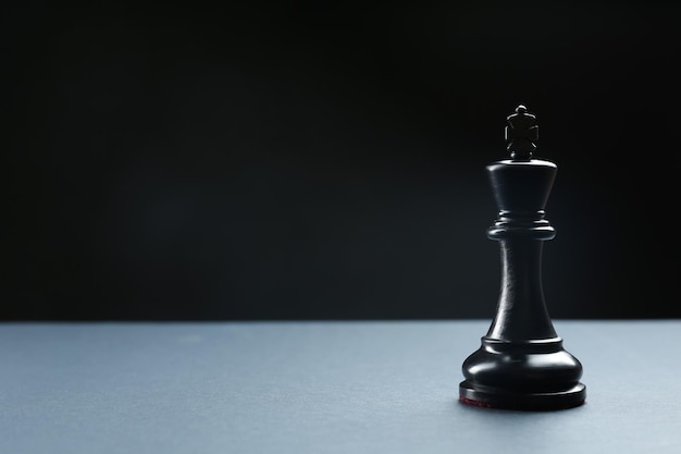 Black king on table against dark background space for text Chess piece