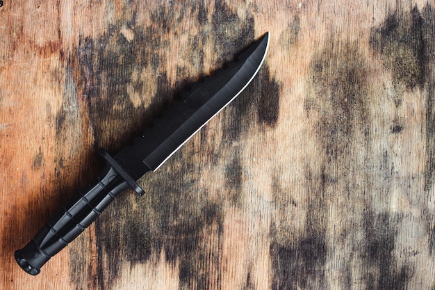 写真 木製の背景に黒いナイフ狩猟ナイフ高品質のステンレス鋼で作られた戦闘アーミー ナイフ海兵隊ナイフ