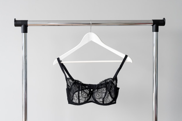 Black lace bra hanging on a hanger. 