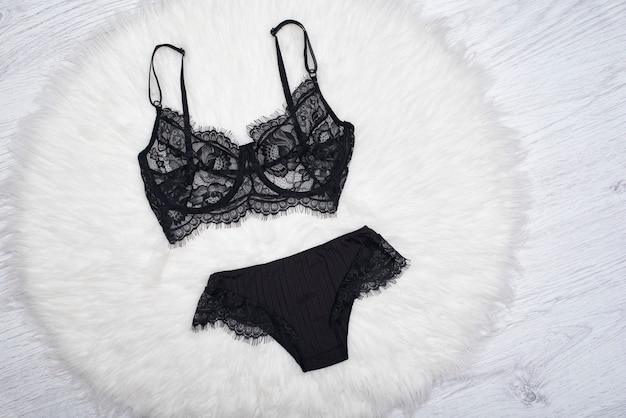 Black lace lingerie on the white fur. Fashion concept