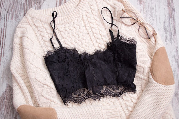 Black lace top on a beige sweater, glasses