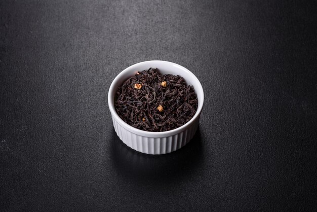 Black largeleaf tea as a background Texture of dry black tea leaves Dark background