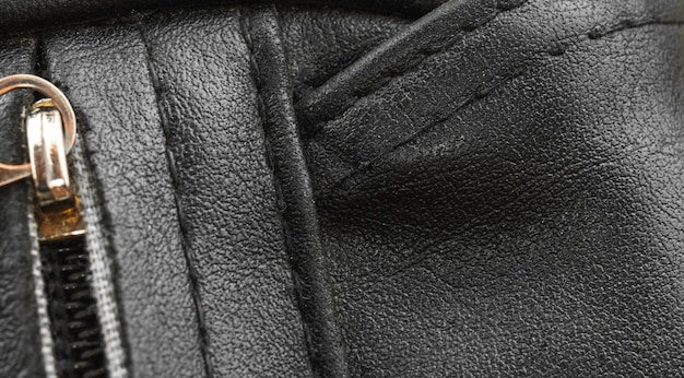 Black leather bag close-up with texture detailed surface, the seams background