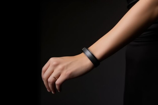 A black leather band on a wrist with a black background.