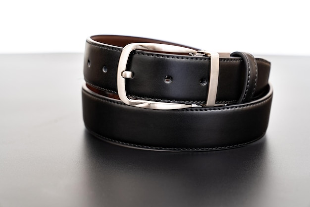 black leather belt on a black table. accessories store for men