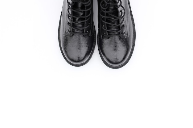흰색 표면에 검은 가죽 부츠. 유행 현대 여성 신발 군사 스타일.