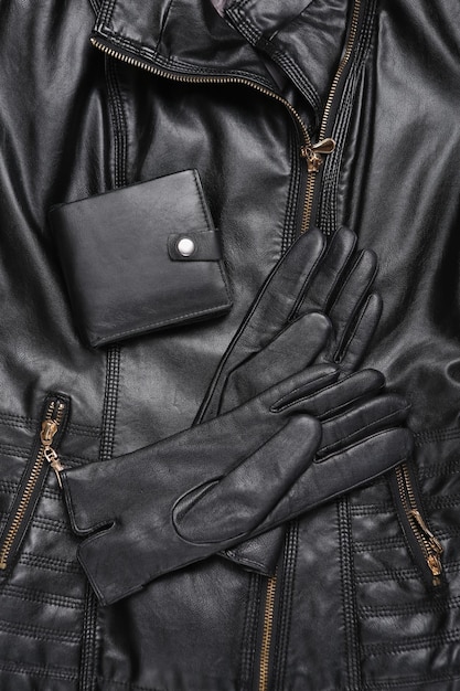 Black leather gloves and wallet on a leather jacket