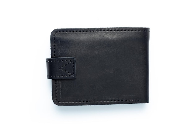 Black leather wallet on a button on a white background Top view