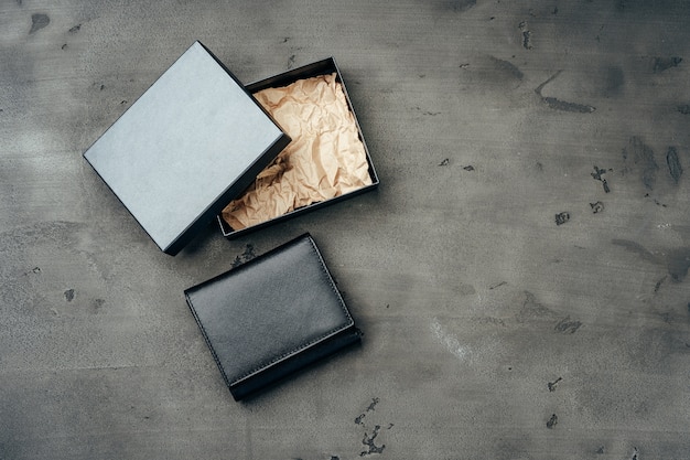 Black leather wallet on grey concrete background