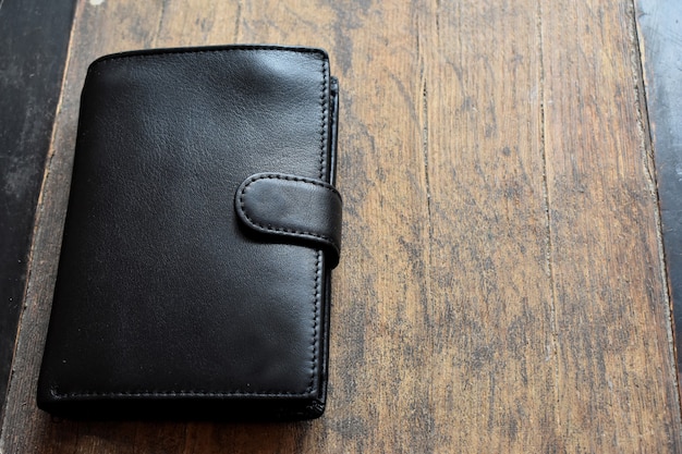 black leather wallet on a light wooden background