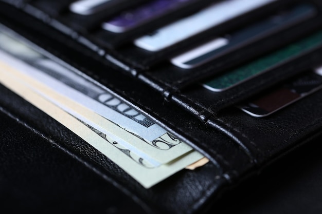 Black leather wallet with credit cards and money close up