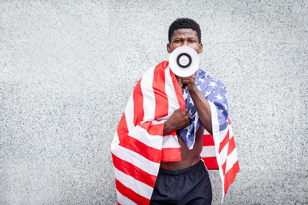 Black lives matter concept Aggressive african american guy with usa flag protests and shouts