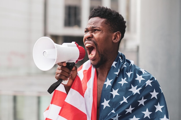 Black lives matter concept Agressieve Afro-Amerikaanse man met protesten tegen de Amerikaanse vlag