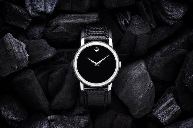 Black luxury watch on black coals background