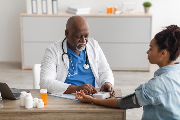 Black male doctor checking measuring pressure on patients hand