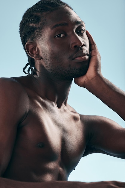 Photo black man beauty with grooming and face shirtless in studio and isolated on blue background hygiene skincare and african model with muscle clean dermatology and natural cosmetics in portrait